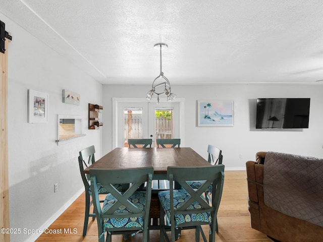 1475 Mars St, Merritt Island, FL 32953 - dining space with light wood finished floors, baseboards, a textured ceiling, and a chandelier