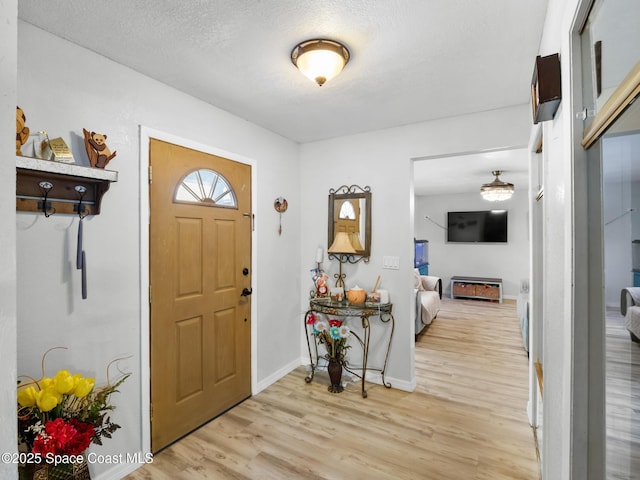 1475 Mars St, Merritt Island, FL 32953 - entrance foyer with light wood-style floors, baseboards, and a textured ceiling