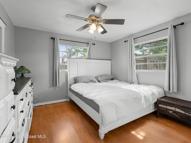1475 Mars St, Merritt Island, FL 32953 - bedroom with multiple windows, light wood-type flooring, a ceiling fan, and baseboards