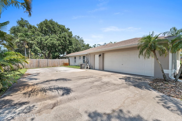 6858 Sweet Bay Ct, Cocoa, FL 32927 - view of side of property with stucco siding, driveway, an attached garage, and central air condition unit