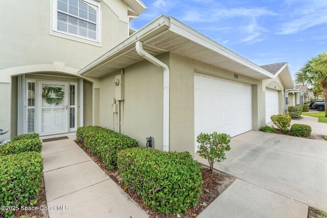 262 Prince William Ct, Satellite Beach, FL 32937 - property entrance featuring stucco siding, an attached garage, and concrete driveway