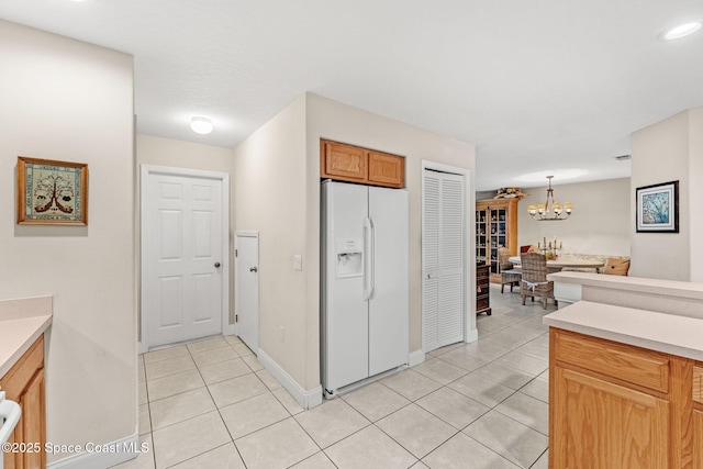 262 Prince William Ct, Satellite Beach, FL 32937 - kitchen featuring white fridge with ice dispenser, light tile patterned floors, a chandelier, light countertops, and hanging light fixtures
