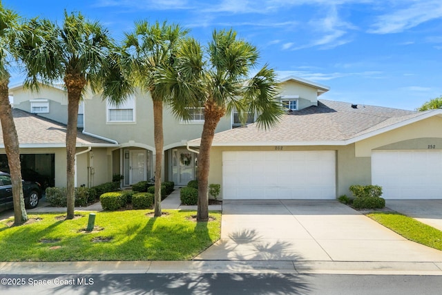 262 Prince William Ct, Satellite Beach, FL 32937 - view of front of property featuring stucco siding, a front lawn, an attached garage, driveway, and roof with shingles