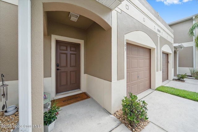 2500 Revolution St Unit 103, Melbourne, FL 32935 - doorway to property with stucco siding and driveway