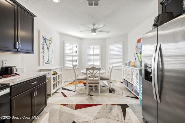 4554 Magenta Isles Dr, Melbourne, FL 32904 - kitchen with stainless steel fridge, ceiling fan, and a textured ceiling