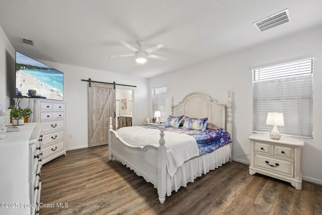 4554 Magenta Isles Dr, Melbourne, FL 32904 - bedroom with a barn door, multiple windows, and dark wood finished floors