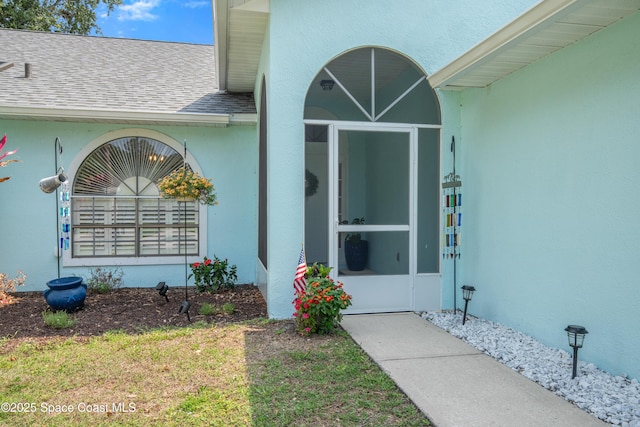 149 Kyle Ct NE, Palm Bay, FL 32907 - property entrance with stucco siding and roof with shingles