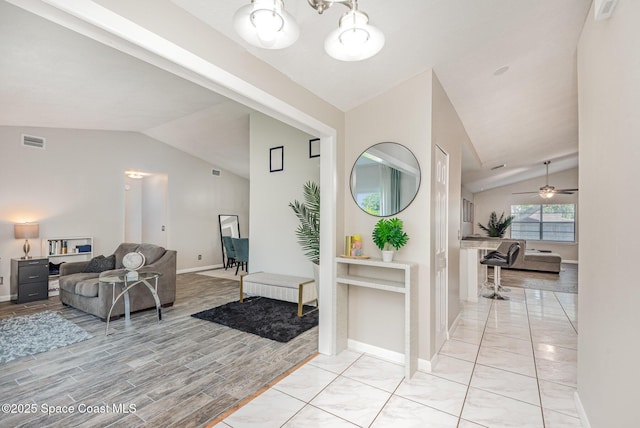5145 Fay Blvd, Cocoa, FL 32927 - entrance foyer featuring lofted ceiling, baseboards, a ceiling fan, a chandelier, and light wood finished floors