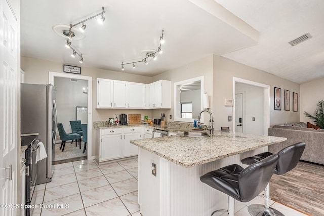 5145 Fay Blvd, Cocoa, FL 32927 - kitchen with a sink, a peninsula, black electric range, a breakfast bar area, and light stone counters