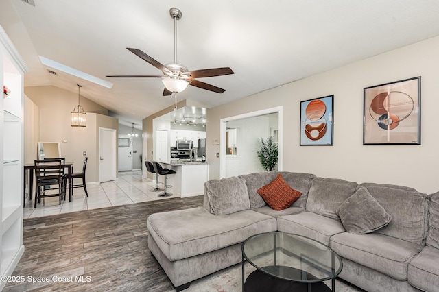 5145 Fay Blvd, Cocoa, FL 32927 - living area with light wood finished floors, ceiling fan, vaulted ceiling, and a chandelier