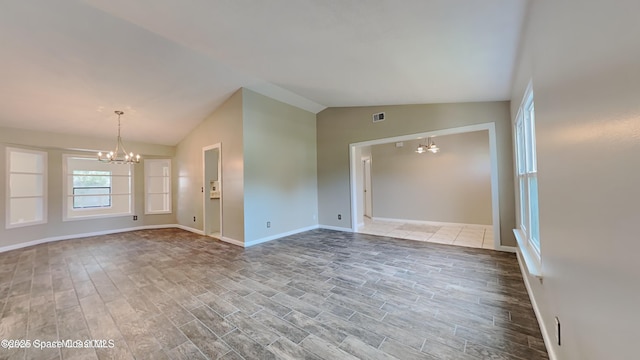 5145 Fay Blvd, Cocoa, FL 32927 - empty room featuring a chandelier, lofted ceiling, wood finished floors, and baseboards