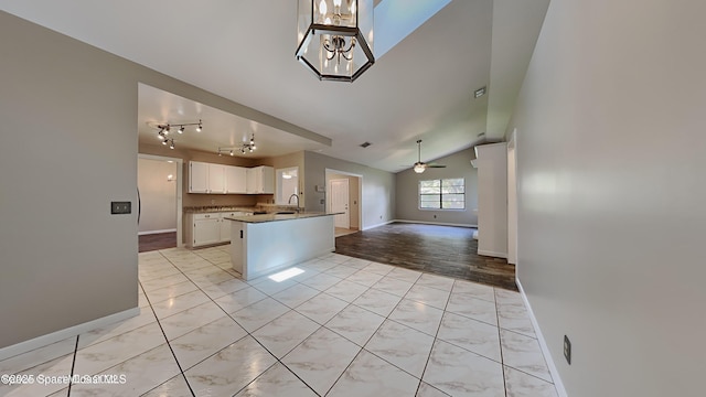 5145 Fay Blvd, Cocoa, FL 32927 - kitchen featuring open floor plan, baseboards, a sink, white cabinetry, and a ceiling fan