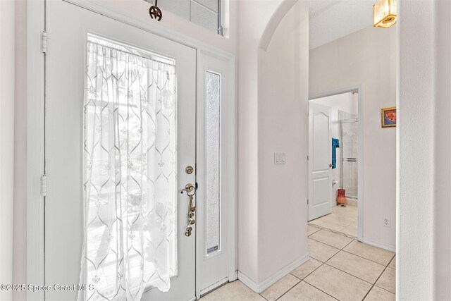 4341 Aberdeen Cir, Rockledge, FL 32955 - entryway with arched walkways, light tile patterned floors, and baseboards