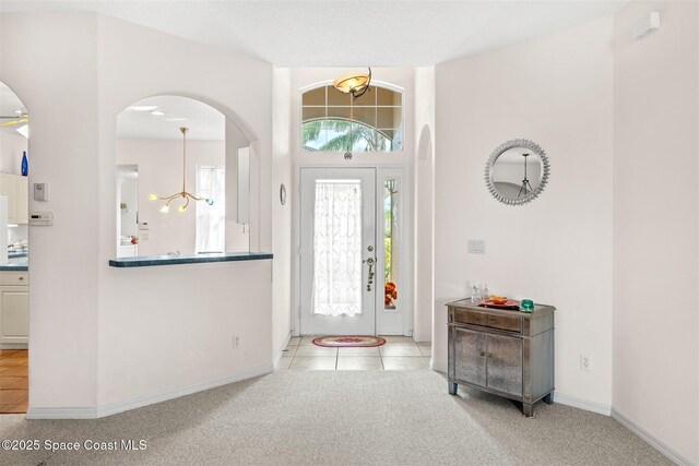 4341 Aberdeen Cir, Rockledge, FL 32955 - foyer featuring arched walkways, a chandelier, baseboards, and tile patterned floors