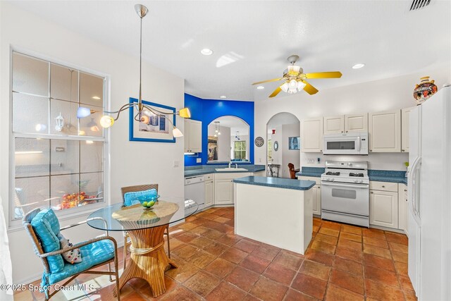 4341 Aberdeen Cir, Rockledge, FL 32955 - kitchen with white appliances, a sink, a kitchen island, a ceiling fan, and white cabinets