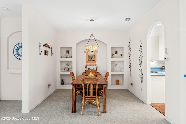 4341 Aberdeen Cir, Rockledge, FL 32955 - dining area featuring built in shelves, light carpet, baseboards, and arched walkways