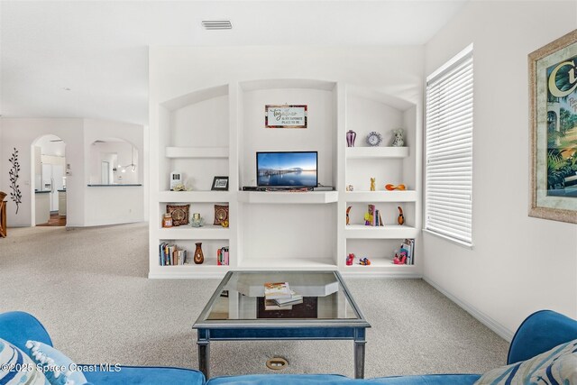4341 Aberdeen Cir, Rockledge, FL 32955 - living room with carpet floors, built in features, arched walkways, and baseboards