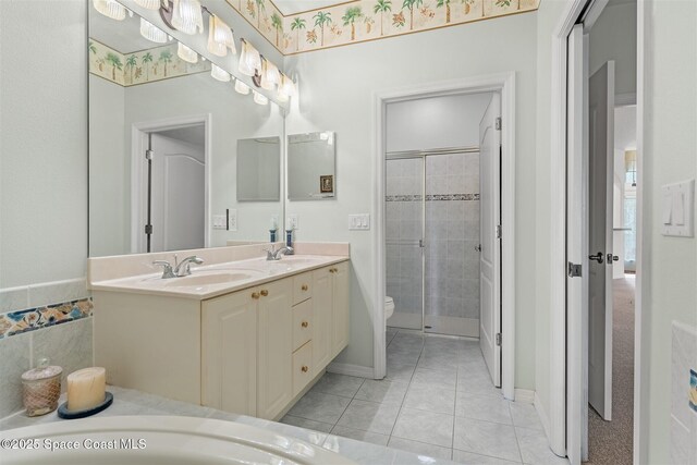 4341 Aberdeen Cir, Rockledge, FL 32955 - full bath with double vanity, toilet, a stall shower, tile patterned flooring, and baseboards