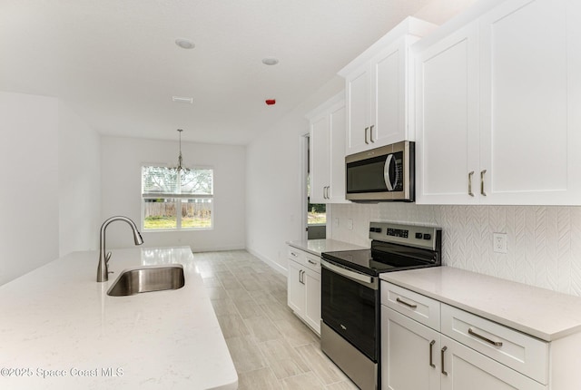 1795 Fallon Blvd NE Unit 06, Palm Bay, FL 32907 - kitchen featuring appliances with stainless steel finishes, a sink, white cabinets, and backsplash