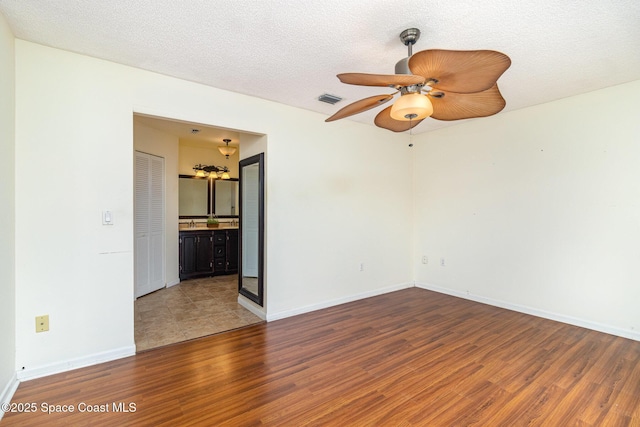 409 Americana Blvd NE, Palm Bay, FL 32907 - empty room with wood finished floors, a ceiling fan, baseboards, and a textured ceiling