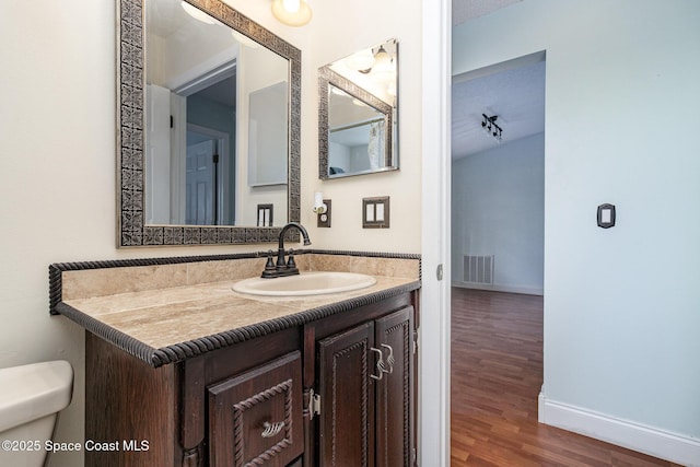 409 Americana Blvd NE, Palm Bay, FL 32907 - bathroom featuring toilet, baseboards, vanity, and wood finished floors