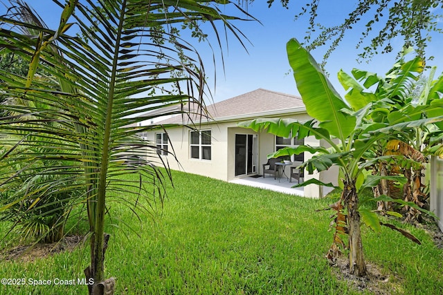 910 Swiss Pointe Ln, Rockledge, FL 32955 - back of property with stucco siding, a shingled roof, a patio, and a yard