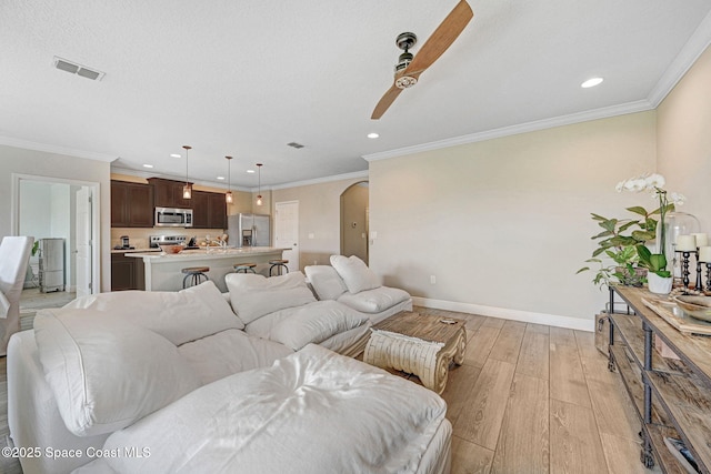 910 Swiss Pointe Ln, Rockledge, FL 32955 - living area with ceiling fan, light wood-style flooring, recessed lighting, crown molding, and arched walkways
