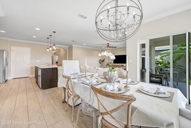 910 Swiss Pointe Ln, Rockledge, FL 32955 - dining space featuring recessed lighting, a chandelier, light wood-style floors, arched walkways, and ornamental molding