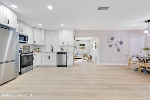 1340 Lester Ct, Merritt Island, FL 32952 - kitchen featuring appliances with stainless steel finishes, baseboards, white cabinets, light wood-style flooring, and recessed lighting
