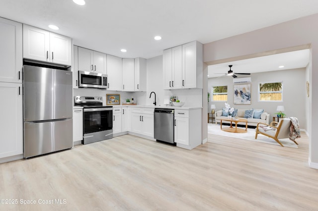 1340 Lester Ct, Merritt Island, FL 32952 - kitchen with stainless steel appliances, light wood-style floors, recessed lighting, light countertops, and white cabinets