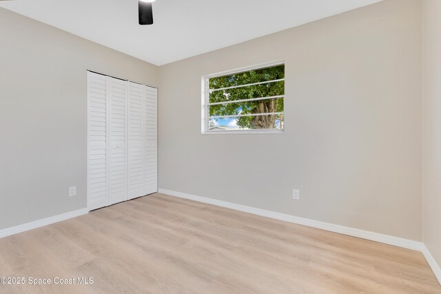 1340 Lester Ct, Merritt Island, FL 32952 - unfurnished bedroom featuring baseboards, light wood finished floors, a closet, and a ceiling fan