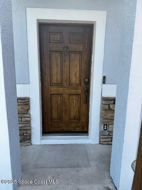 982 Colonial Ave SE, Palm Bay, FL 32909 - doorway to property with stucco siding