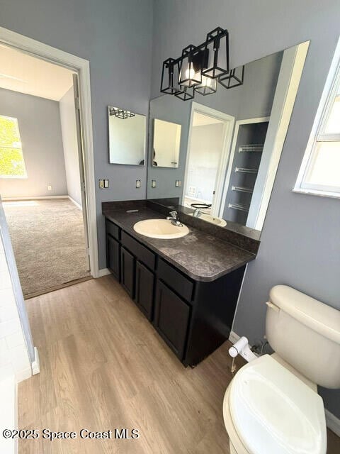 982 Colonial Ave SE, Palm Bay, FL 32909 - bathroom with wood finished floors, vanity, toilet, baseboards, and a high ceiling