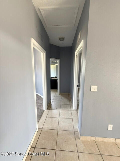 982 Colonial Ave SE, Palm Bay, FL 32909 - hallway with light tile patterned floors and baseboards