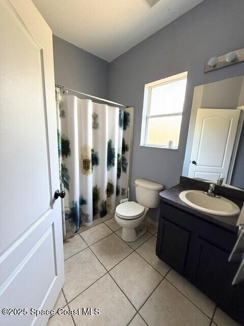 982 Colonial Ave SE, Palm Bay, FL 32909 - bathroom with toilet, vanity, tile patterned flooring, and a shower with shower curtain