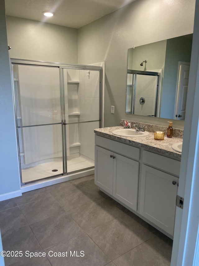 7055 Topaz Dr, Grant-Valkaria, FL 32949 - bathroom featuring a shower stall, double vanity, and tile patterned floors