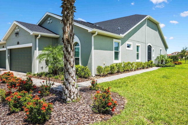 2611 Ballydoyle Ln, Melbourne, FL 32940 - view of side of home with stucco siding, a yard, an attached garage, a shingled roof, and driveway