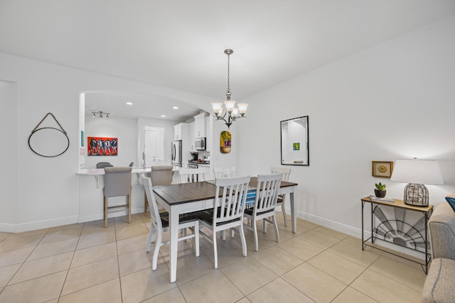 2611 Ballydoyle Ln, Melbourne, FL 32940 - dining space featuring light tile patterned floors, a chandelier, baseboards, recessed lighting, and arched walkways