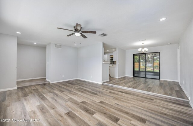 1521 Baker St NE, Palm Bay, FL 32907 - unfurnished living room with a chandelier, a ceiling fan, light wood finished floors, recessed lighting, and baseboards
