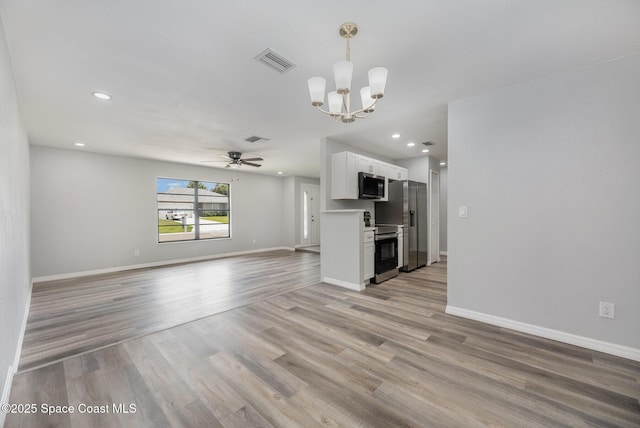 1521 Baker St NE, Palm Bay, FL 32907 - unfurnished living room featuring a ceiling fan, light wood-style floors, a chandelier, baseboards, and recessed lighting