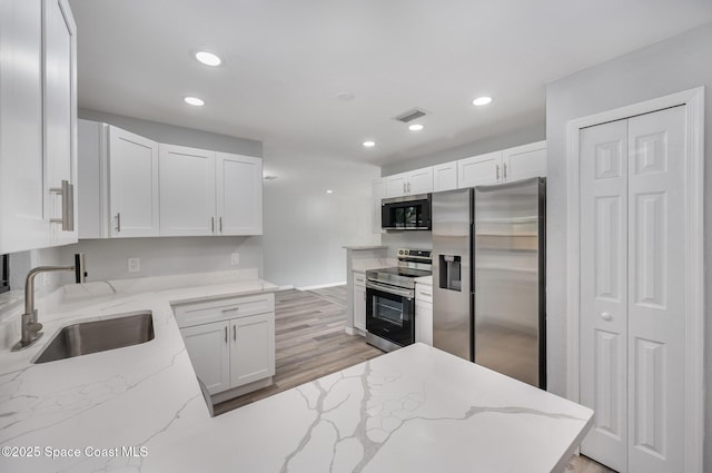 1521 Baker St NE, Palm Bay, FL 32907 - kitchen featuring stainless steel appliances, a sink, white cabinetry, and recessed lighting