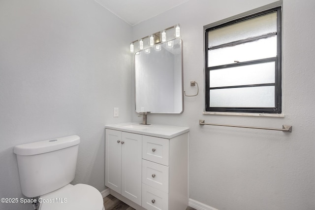 1521 Baker St NE, Palm Bay, FL 32907 - bathroom featuring toilet, vanity, baseboards, and wood finished floors
