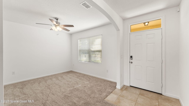 422 Moray Dr SW, Palm Bay, FL 32908 - foyer featuring arched walkways, ceiling fan, baseboards, light carpet, and light tile patterned floors
