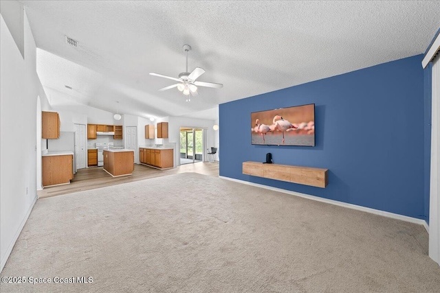 3380 Toledo Ave, Palm Bay, FL 32908 - unfurnished living room featuring light carpet, baseboards, vaulted ceiling, ceiling fan, and a textured ceiling