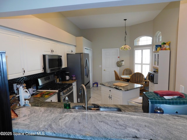 1076 Pine Creek Cir NE, Palm Bay, FL 32905 - kitchen featuring appliances with stainless steel finishes, light stone counters, a sink, white cabinets, and lofted ceiling