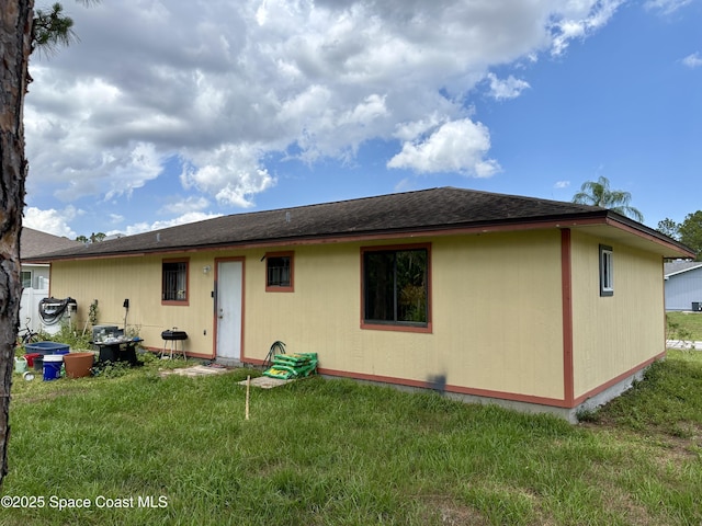 322 Ixora Ave NW, Palm Bay, FL 32907 - back of property with a lawn and roof with shingles