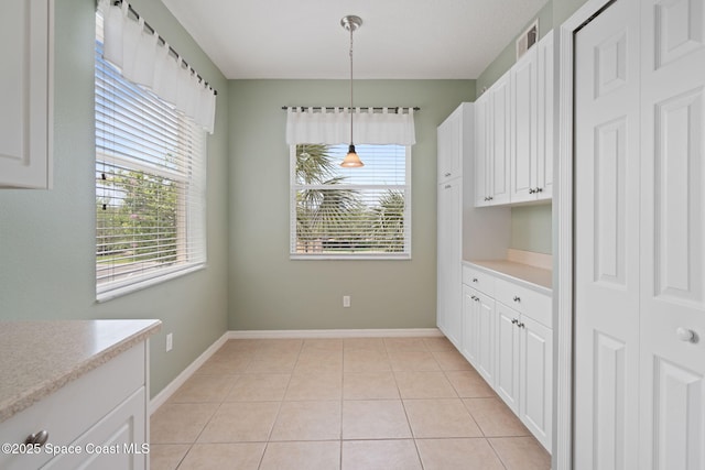 6848 Toland Dr Unit 208, Melbourne, FL 32940 - unfurnished dining area with plenty of natural light, light tile patterned flooring, and baseboards