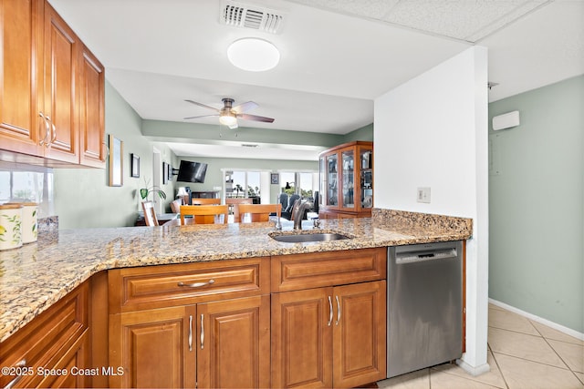 1700 N Atlantic Ave Unit 133, Cocoa Beach, FL 32931 - kitchen featuring dishwasher, a peninsula, brown cabinets, and light stone counters