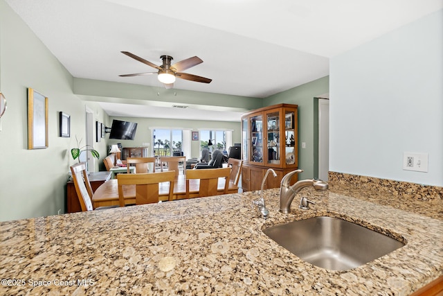 1700 N Atlantic Ave Unit 133, Cocoa Beach, FL 32931 - kitchen with a sink, a ceiling fan, and light stone counters