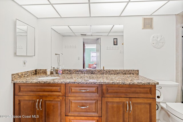 1700 N Atlantic Ave Unit 133, Cocoa Beach, FL 32931 - bathroom with toilet, a drop ceiling, vanity, and a shower